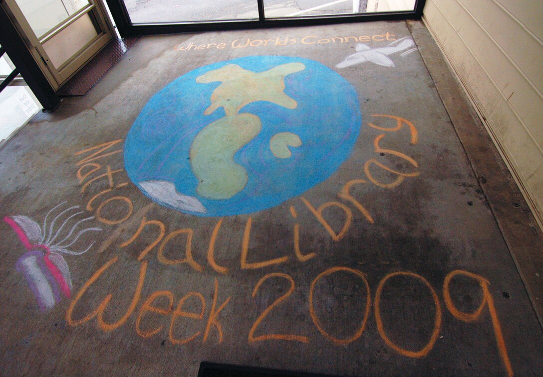 Chalk artwork is displayed on the foyer outside the library entrance for visitors to enjoy in observance of National Library Week, April 12 to 19. The work was done by Karla Henderson, a base library aide. (U.S. Air Force photo/ Bobby Jones)
