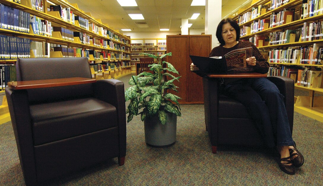 Bertha Castillo sits in one of the new leather chairs while leisurely reading a magazine in the lobby area of the library Monday. Ms. Castillo is the mother-in-law of Staff Sgt. Joseph Reyes, 316th Security Forces Squadron Raven. (U.S. Air Force photo/ Bobby Jones)