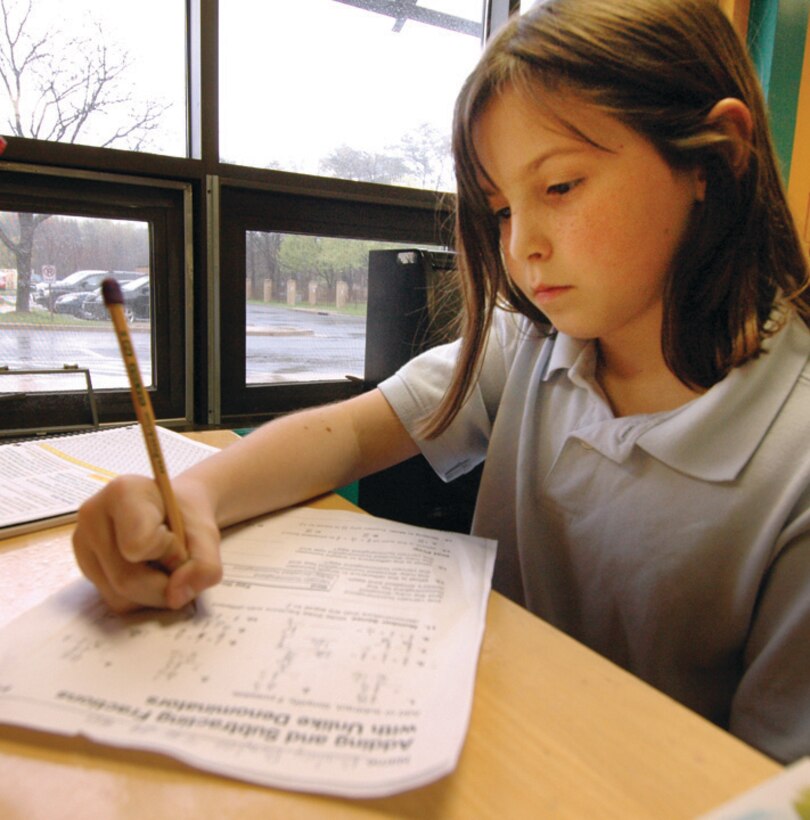 Bailey Boyles, 10, works on adding and subtracting fractions at the Andrews Youth Center Wednesday. Bailey is the daughter of Navy Chief Petty Officer Richard Boyles, Fleet Logistics Squadron 53. (U.S. Air Force photo/ Bobby Jones)