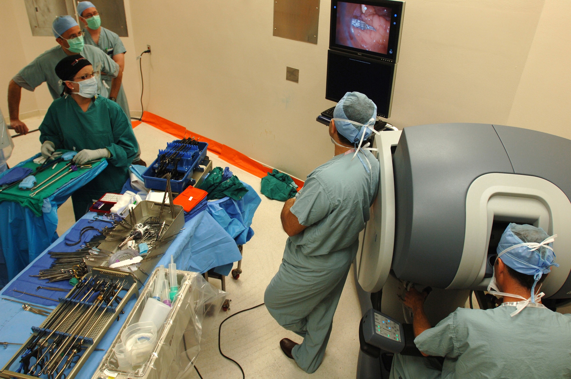 Medical personnel look at a monitor while Lt. Col. (Dr.) Kyle Weld (right) performs a laparoscopic prostatectomy, the surgical removal of prostate cancer.  Dr. Weld, staff urologist, 59th Medical Wing, was the first Air Force doctor to use a robot in surgery. The robot provides a magnified, high-definition, three-dimensional view for the physician. A full service adult urology clinic is available at Wilford Hall. Most urologic surgical procedures are performed at San Antonio Military Medical Center. (U.S. Air Force photo/Senior Airman Nicole Roberts)  
