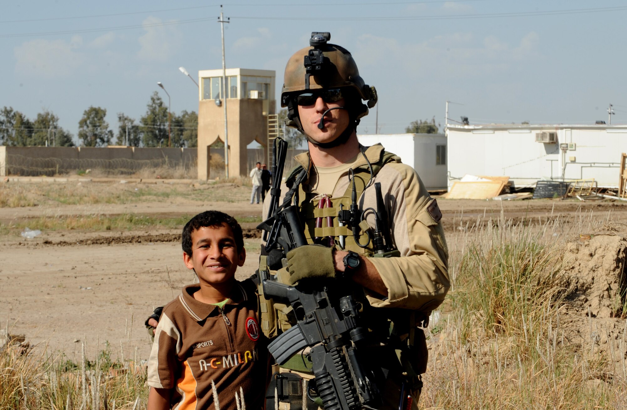 U.S. Air Force Combat Rescue Officer Capt. Robert Wilson, 64th Expeditionary Rescue Squadron, Joint Base Balad, Iraq, takes time for a photograph with an Iraqi boy April 10, 2009, in support of Operation Iraqi Freedom.  (U.S. Air Force photo by Staff Sgt. James L. Harper Jr.)Released