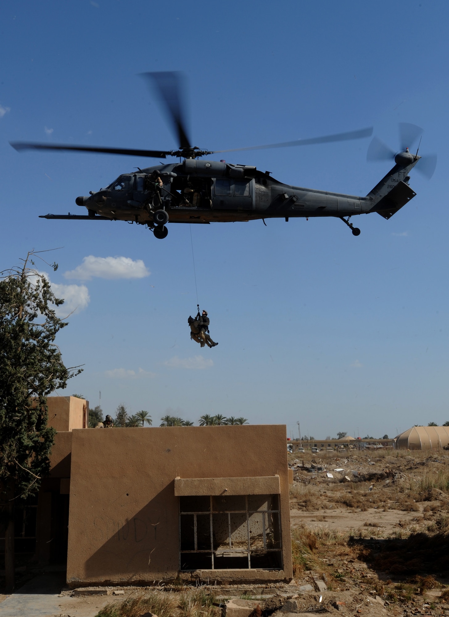 U.S. Air Force Pararescuemen from the 64th Expeditionary Rescue Squadron, Joint Base Balad, Iraq, are hoisted to an HH-60 Pavehawk helicopter outside of Baghdad, Iraq during a proficiency exercise April 10, 2009, in support of Operation Iraqi Freedom.  (U.S. Air Force photo by Staff Sgt. James L. Harper Jr.)