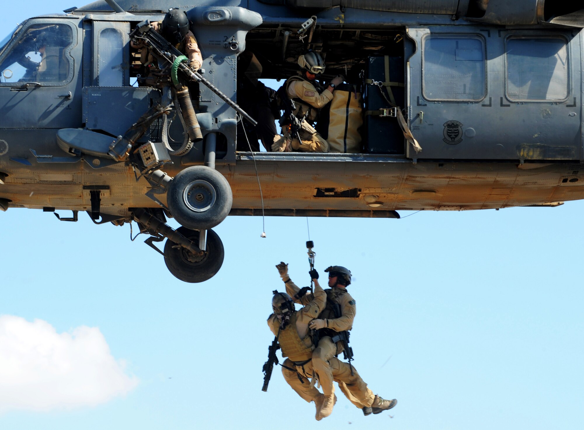 U.S. Air Force Pararescuemen from the 64th Expeditionary Rescue Squadron, Joint Base Balad, Iraq, are hoisted into an HH-60 Pavehawk helicopter outside of Baghdad, Iraq during a proficiency exercise April 10, 2009, in support of Operation Iraqi Freedom.  (U.S. Air Force photo by Staff Sgt. James L. Harper Jr.)