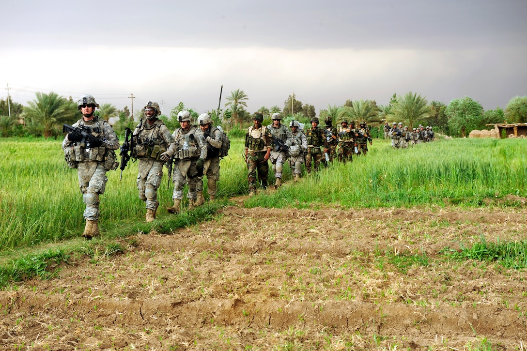 U.S. Army and Iraqi soldiers march to their next objective in Owesat, Iraq, April 12, 2009. The soldiers are assigned to the 1st Armored Division's 1st Battalion, 6th Infantry Regiment, 2nd Brigade Combat Team.