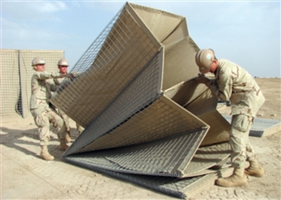 U.S. Navy sailors assigned to Naval Mobile Construction Battalion 5 lift a collapsible wire mesh gabion into position at Camp Bastion, Afghanistan, on April 11, 2009.  Naval Mobile Construction Battalion 5 is deployed to Afghanistan to provide contingency construction support to allies and members of the NATO International Security Assistance Force.  Naval Mobile Construction Battalion 5 is one of the Naval Expeditionary Combat Command war fighting support elements providing host nation contingency construction support and security.  