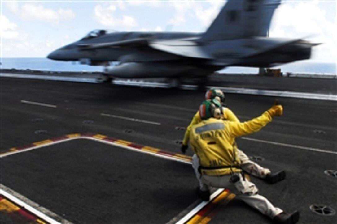 U.S. Navy Lt. Jeremy Gross, foreground, and Lt. Hector Laus give the signal to launch an F/A-18C Hornet aboard the aircraft carrier USS John C. Stennis in the Pacific Ocean, April 15, 2009. Stennis is on a scheduled six-month deployment to the western Pacific Ocean.