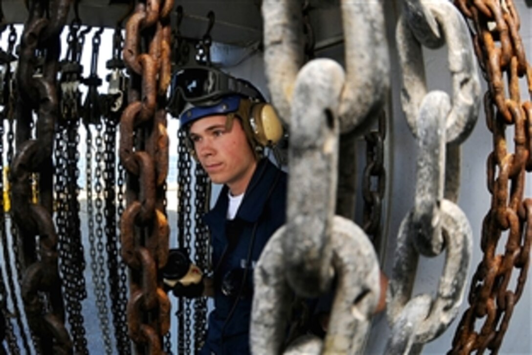 U.S. Navy Seaman Joseph Bean mans a sound-powered telephone aboard the amphibious command ship USS Blue Ridge during a crash and salvage drill simulating an emergency helicopter landing and crash in the Pacific Ocean, April 15, 2009.
