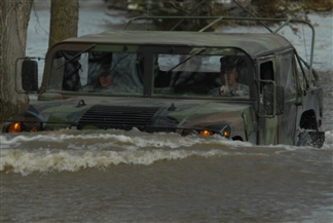 U.S. Army Staff Sgt. William Griffin (right) of the 136th Combat Sustainment Support Battalion and Spc. Jessica Sandberg of the 132nd Quartermaster Battalion use a Humvee to make their way down a flooded street in Fort Ransom, N.D., on April 15, 2009.  The soldiers are making welfare visits to residents in rural areas affected by Sheyenne River floodwaters.  