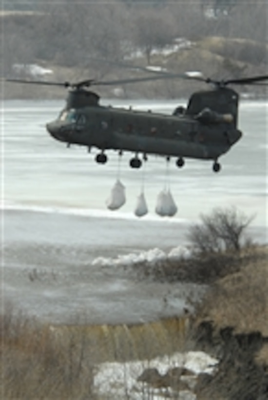 A North Dakota Air National Guard CH-47 Chinook helicopter drops several one-ton sandbags onto the spillway of the Clausen Springs Dam near Kathryn, N.D., on April 15, 2009.  The sandbags will help divert water away from an area of the dam that is being eroded by rising water, which also threatens to flood a local creek.  