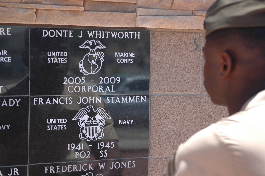 Cpl. Abe Miller, a Combat Logistics Company 16 Marine, pays respects to his friend, Cpl. Donte J. Whitworth, a fellow CLC-16 Marine who died in Iraq Feb. 28, 2009, after a plaque was dedicated in Whitworth’s honor at the Armed Forces Park in Yuma, Ariz., April 17, 2009. Whitworth’s family, the mayor of Yuma and the 1st Maintenance Battalion commanding officer attended the ceremony.