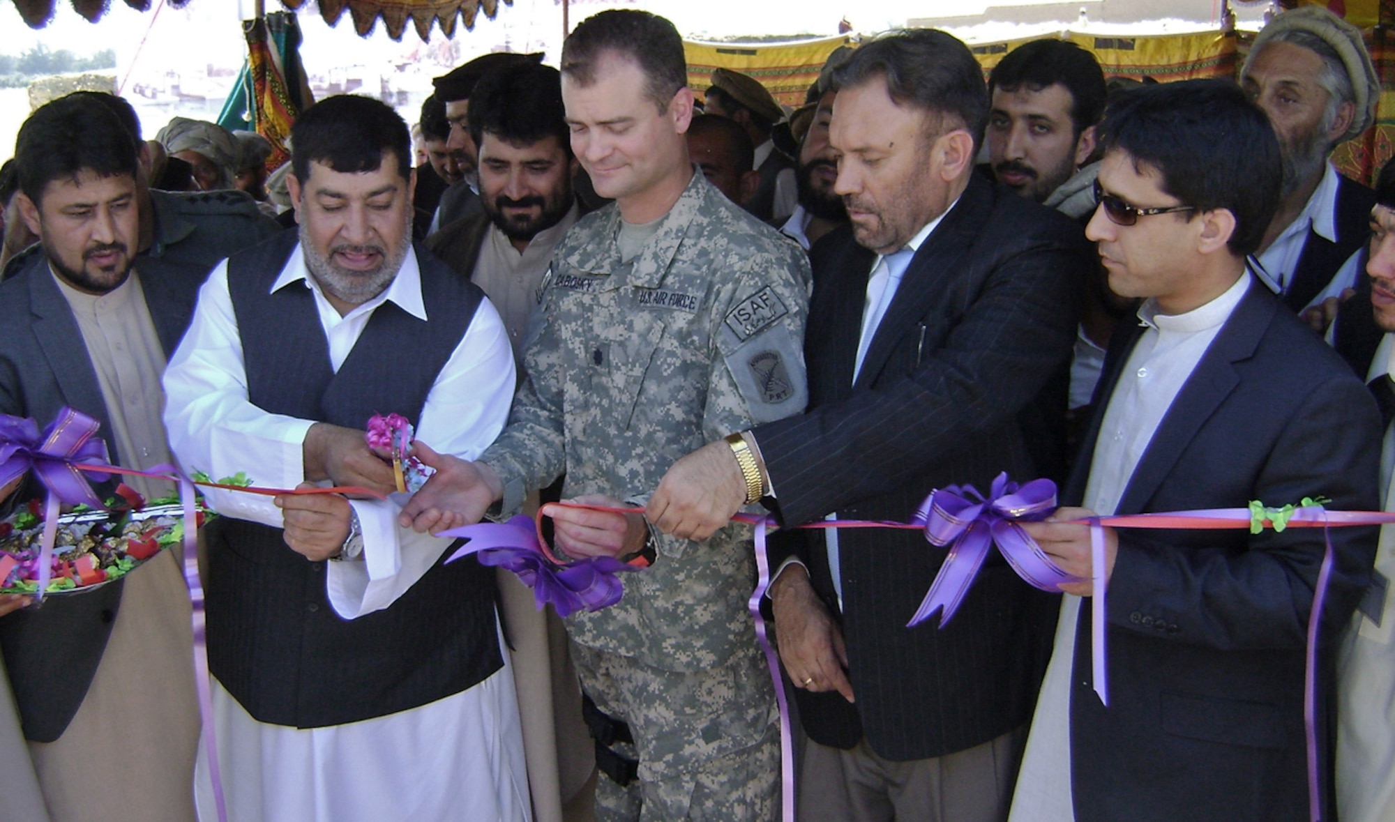 Nangarhar Provincial Governor Gul Agha Sherzai and Nangarhar Provincial Reconstruction Team Commander Lt. Col. Steve Cabosky, take turns cutting the ribbon for the Grand Canal repair project during a ceremony April 12.  The PRT funded the $2.8 million project, which repaired 63 KM of canal and will double the irrigation capacity of the waterway that spans four districts in Nangarhar (Photo by Capt. Dustin Hart)                               