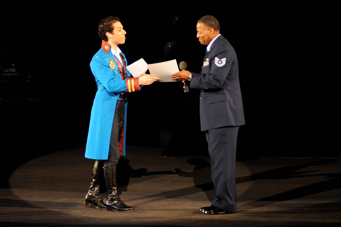 LANGLEY AIR FORCE BASE, Va.-- Alex Ramon, the ringmaster for Ringling Bros. and Barnum & Bailey's new show, "Zing Zang Zoom!" presents the guest ringmaster, Tech. Sgt. Derek Johnson, 497th Intelligence, Surveillance, and Reconnaissance Group, with a certificate of participation at the Norfolk Scope April 18. Sergeant Johnson was chosen to be the guest ringmaster after recently returning from a deployment supporting both U.S. and coalition forces. (U.S. Air Force photo/Airman Rebecca Montez)