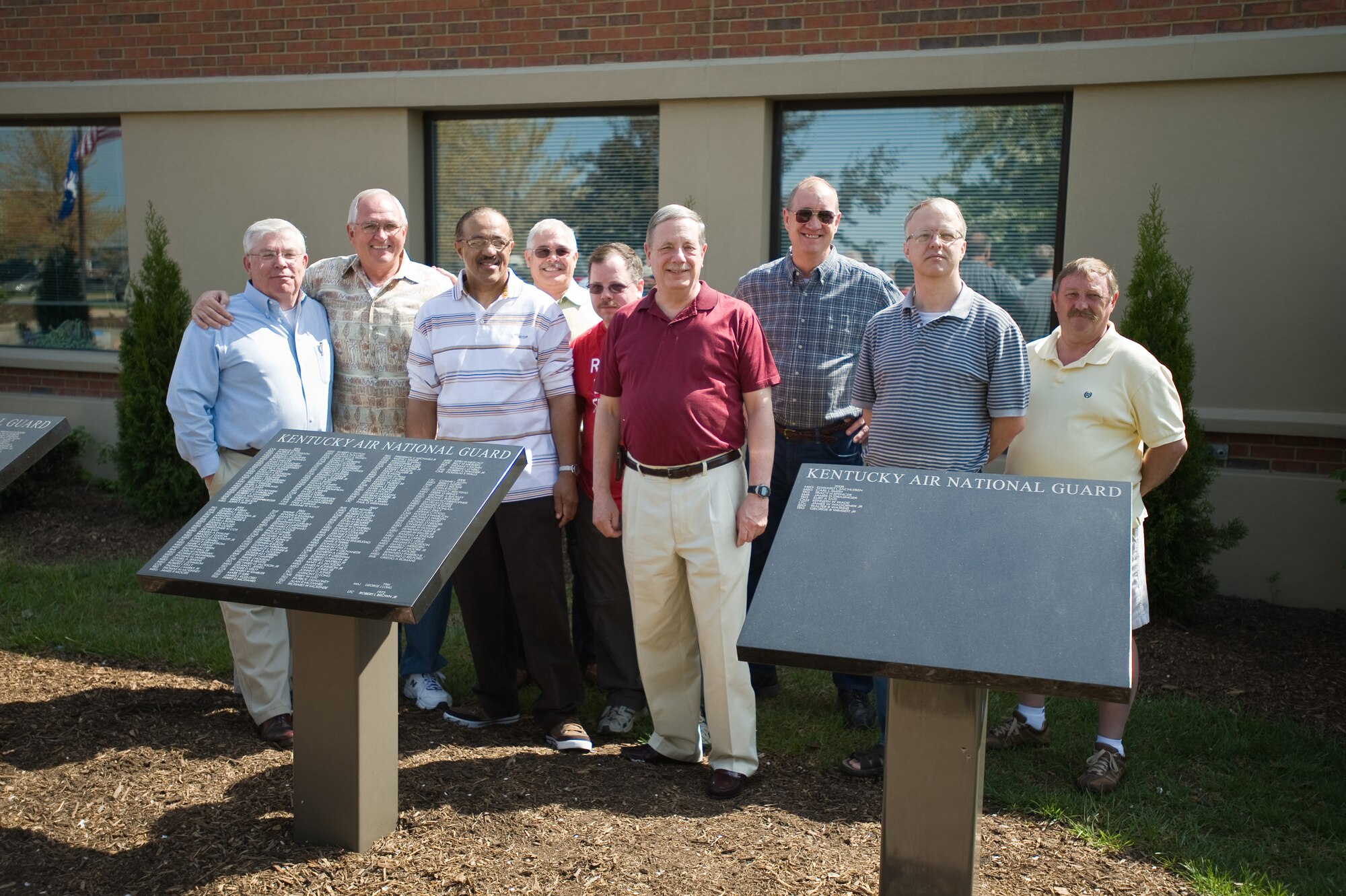 Members of the Kentucky Air National Guard who retired in 2007 stand behind black granite retiree plaques that were dedicated at the base on April 18. (USAF Photo by Capt. Dale Greer.)