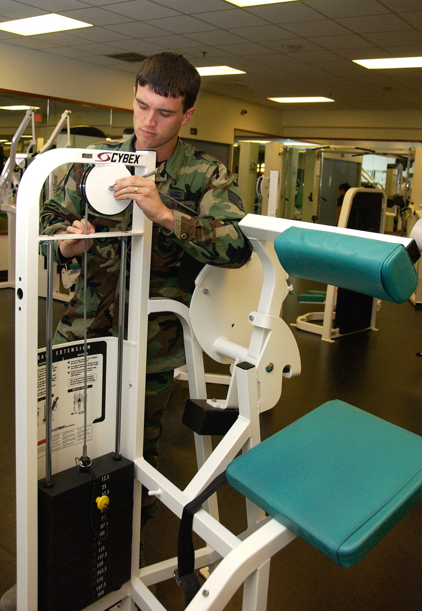 ANDERSEN AIR FORCE BASE, Guam -- Senior Airman Jonathan Ardis, 36th Force Support Squadron fitness specialist, tightens bolts on exercise equipment at the Coral Reef Fitness Center April 20. Airman Ardis recently rendered first aid to individuals in a car accident on Route 1 until first responders arrived April 13. (U.S. Air Force photo by Airman Carissa Wolff)                            