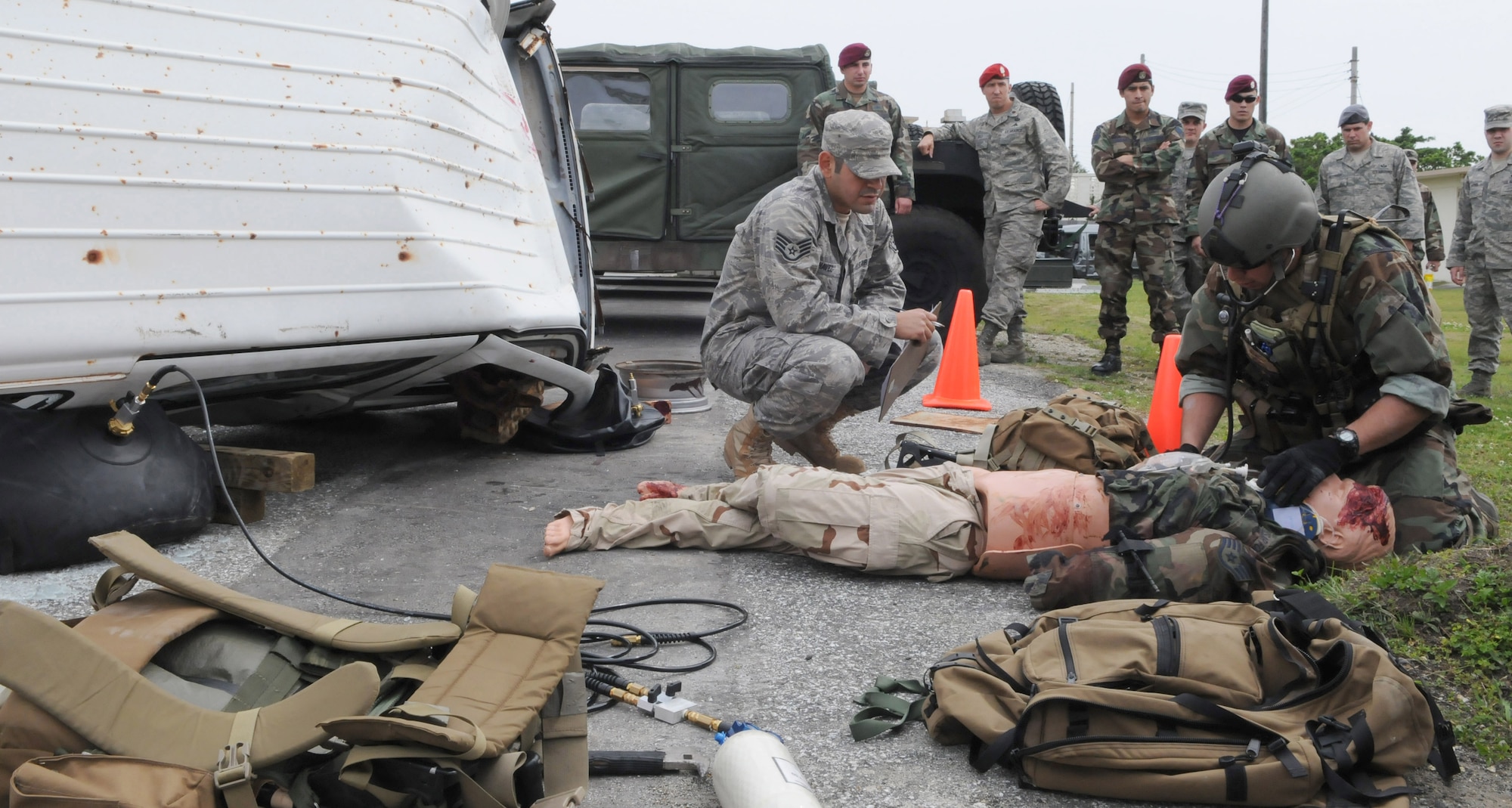 KADENA AIR BASE, Japan -- A pararescueman from the 320th Special Tactics Squadron checks for vitals on a simulated patient after pulling the victim from under a vehicle as the squadron's independent duty medical technician evaluates during a training exercise here April 16. Pararescuemen are the only Department of Defense specialty specifically trained and equipped to conduct conventional or unconventional rescue operations. These battlefield Airmen are personnel recovery specialists with emergency medical capabilities able to locate and save injured personnel anytime, anywhere. (Photo by Tech. Sgt. Aaron Cram)