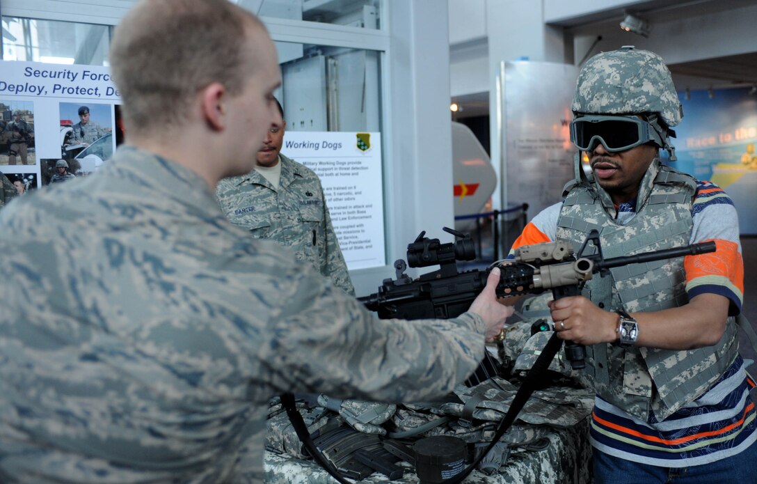 LANGLEY AIR FORCE BASE, Va. -- 2nd Lt. Joseph Eanett, 1st Security Forces Squadron, shows James Adkins a mock weapon at the Virginia Air & Space Center exhibits during Hampton Roads Air Force Week April 19.  This event offered free admission to center, free IMAX movie “Fighter Pilot: Operation Red Flag,” Air Force Recruiting Service “Inspire Tour” Displays, and Langley AFB unit displays.  (U.S. Air Force photo/Airman Rebecca Montez)