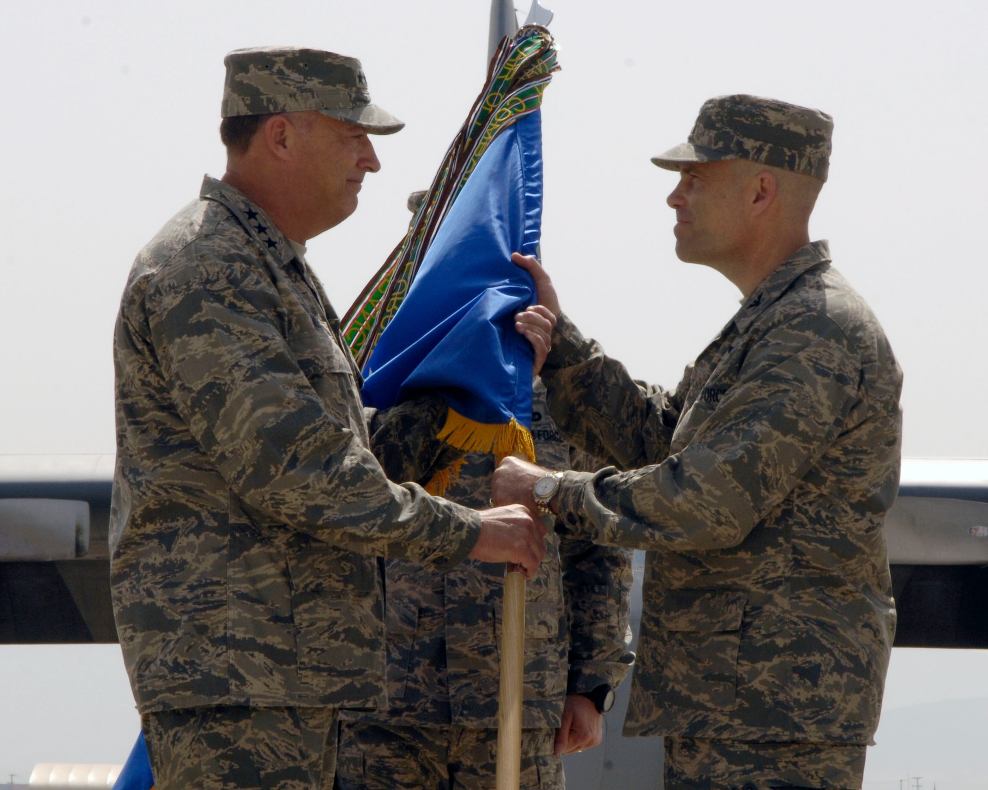 Lt. Gen. Gary North, 9th Air Force and U.S. Air Forces Central commander, hands the 455th Air Expeditionary Wing guidon to Col. Steven Kwast as he assumes command of the wing at Bagram Air Field, Afghanistan, April 18. (U.S. Air Force photo/Senior Airman Steven Doty)(Released)(Released)