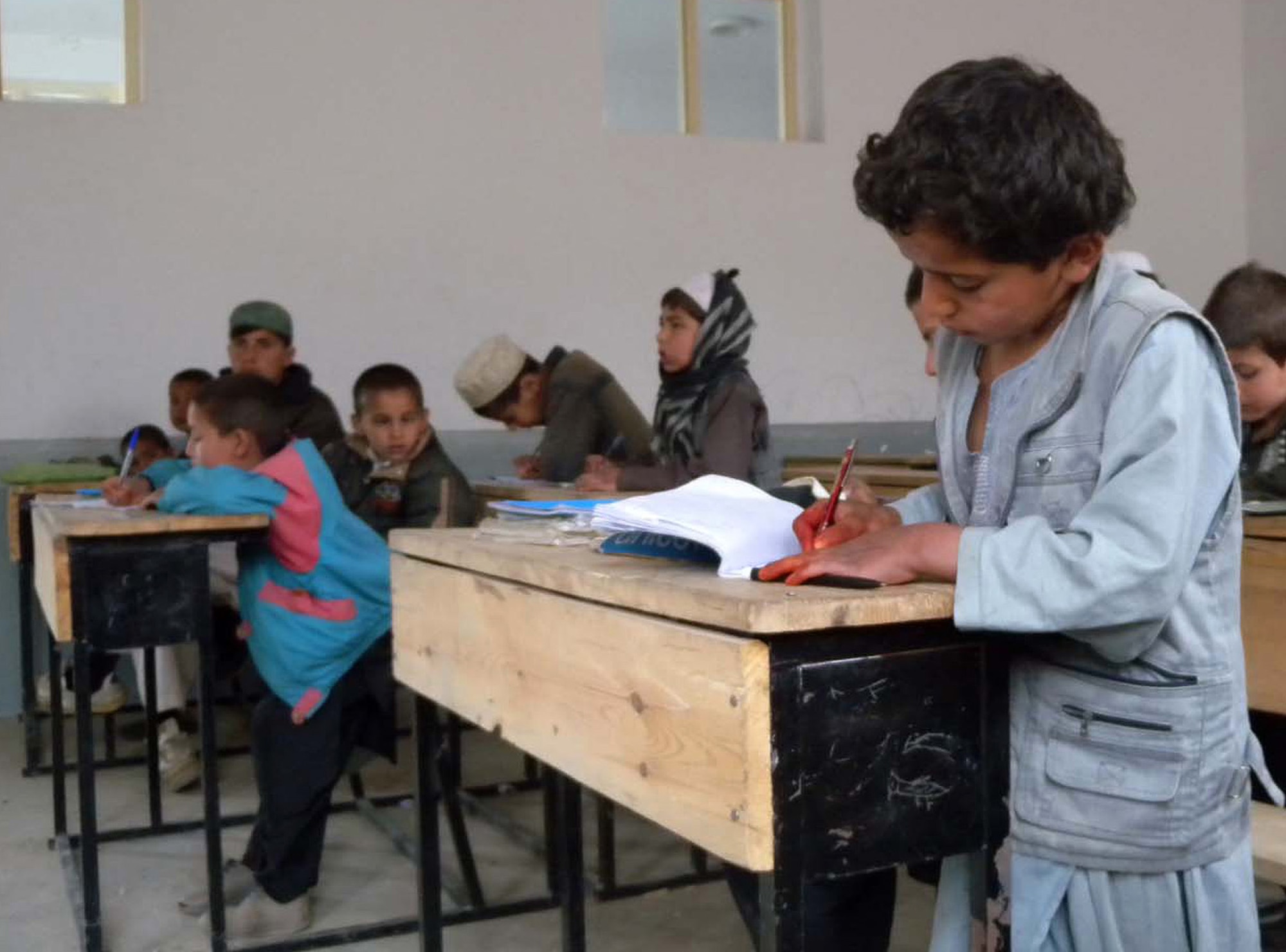 An Afghan boy uses supplies donated to his school by members of a Joint Civilian Military Cooperation and Provincial Reconstruction Team in the Alasay Valley. The teams distributed more than 500 school kits in Sultankhel. (French Army photo by Maj. Patrick Simo)                               