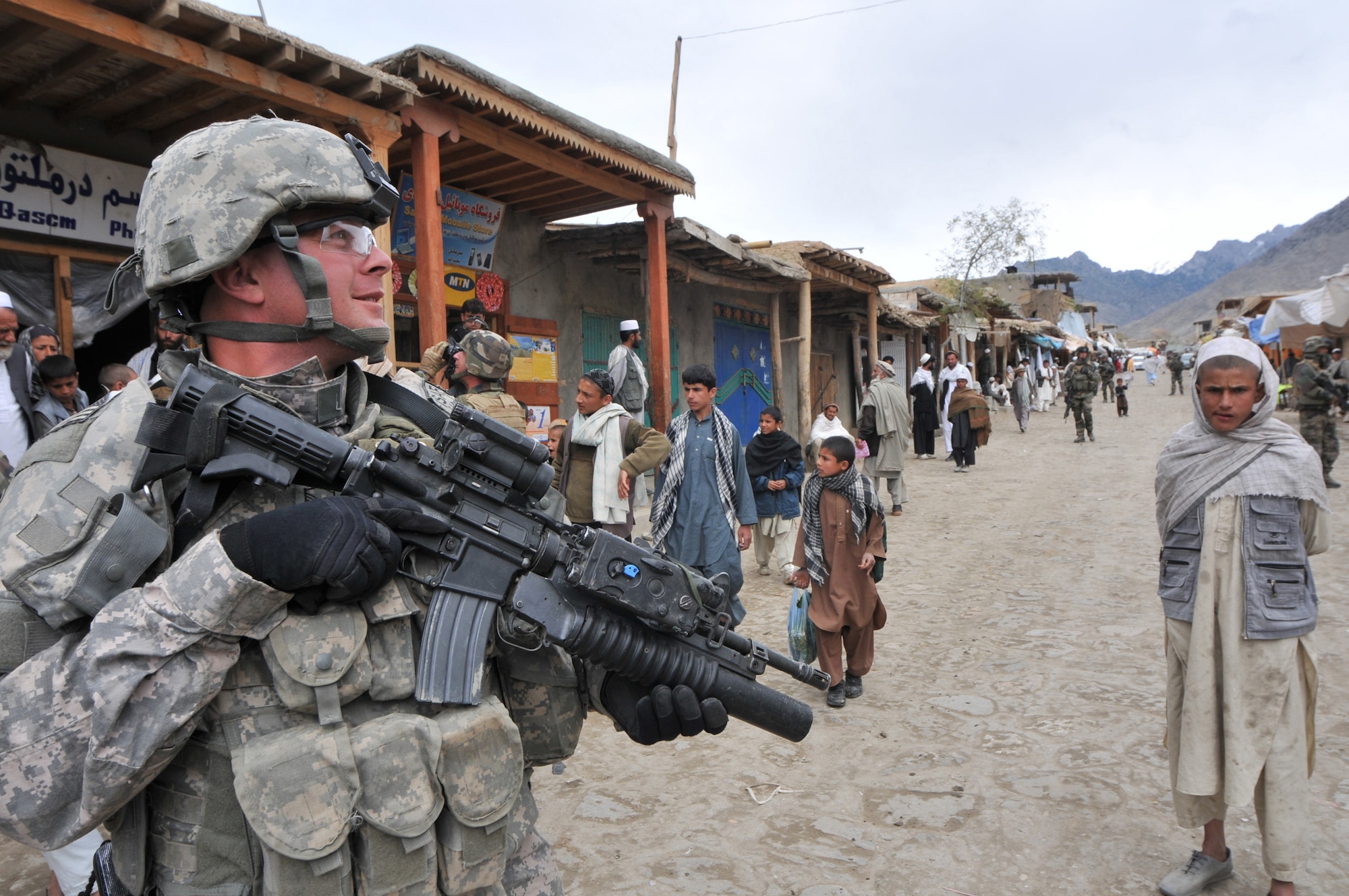Air Force Master Sgt. Todd Davis, Kapisa/Parwan Provincial Reconstruction Team, conducts a foot patrol April 5 through a local market place near the Alasay District Center in Kapisa province. The PRT inspected a school, assisted the Afghan National Army in delivering school supplies to more than 250 area youth and helped local medical providers treat more than 670 patients during a two-day village medical outreach mission in Alasay.  (U.S. Air Force photo by Chief Master Sgt. John Zincone)