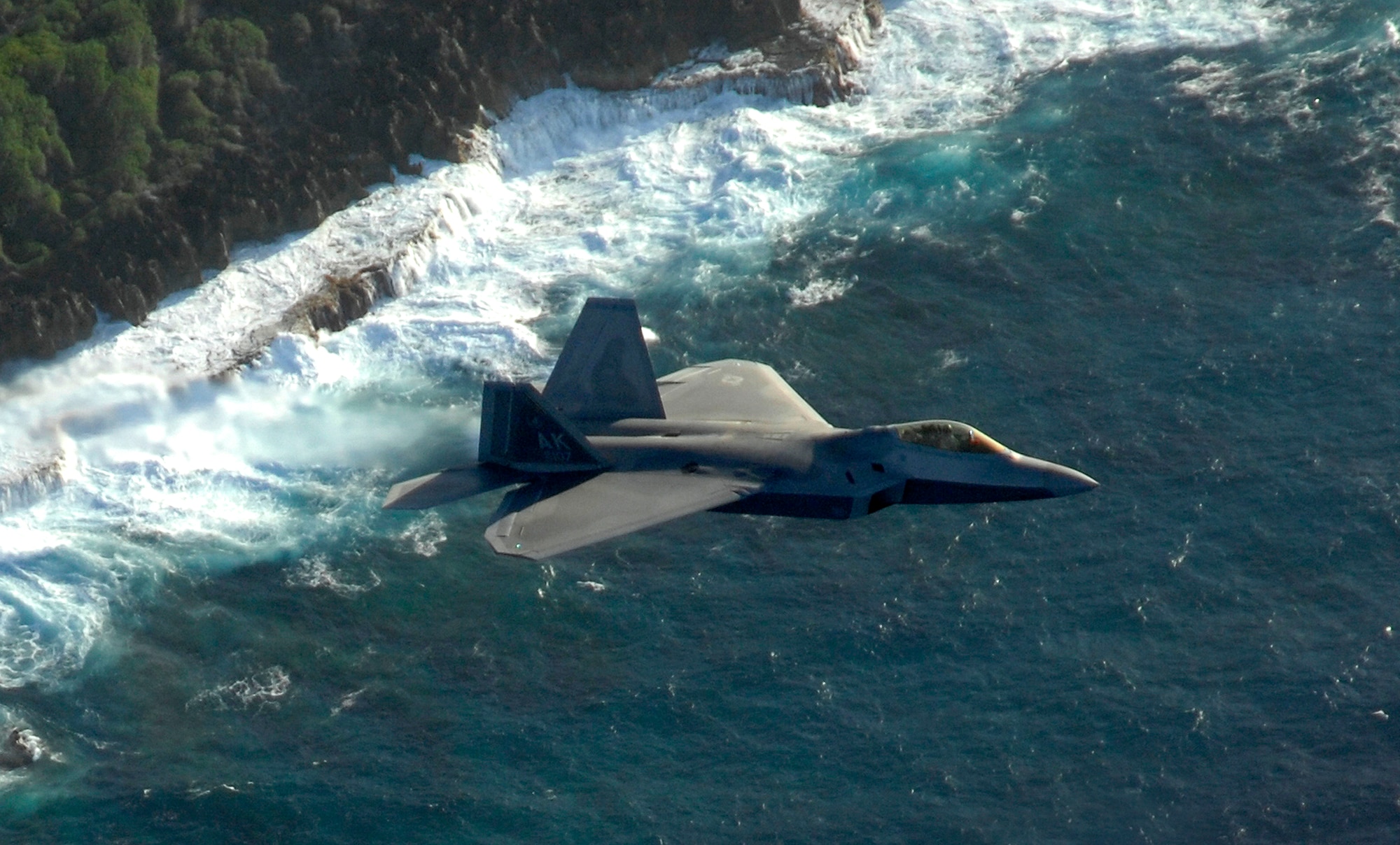 An F-22 Raptor from the 90th Fighter Squadron Elmendorf Air Force Base, Alaska flies over Guam for a training mission April 15.  The 90th FS from Elmendorf Air Force Base, Alaska just completed a 3-month deployment to Andersen as part of a theater security package. These deployments are a prudent measure to maintain a credible deterrent posture and presence for the region and demonstrate a continued U.S. commitment to fulfilling security responsibilities throughout the Western Pacific. (U.S. Air Force photo/ Master Sgt. Kevin J. Gruenwald) released      