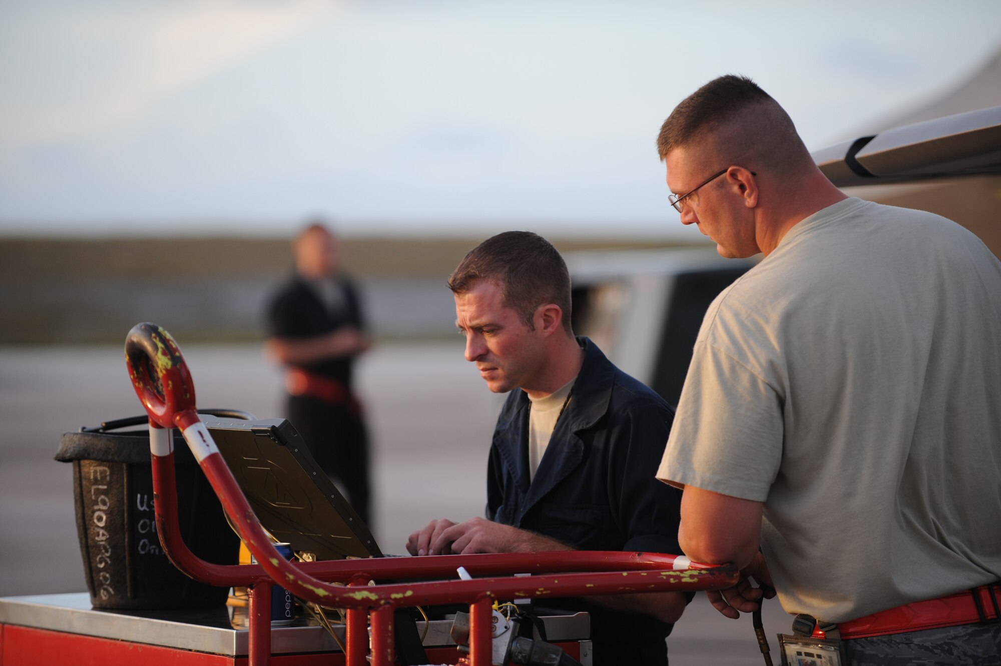 (background) Airman 1st Class Matt Porter inspects an F-22 Raptor while crew chiefs Staff Sgt. Chad Konyndyk and Airman 1st Class Michael Biggs, 36th Expeditionary Maintenance Squadron review F-22 technical data April 15 at Andersen Air Force Base, Guam.  The 90th Fighter Squadron from Elmendorf Air Force Base, Alaska just completed a 3-month deployment to Andersen Air Force Base, Guam as part of a theater security package. The stealth-fighters, along with associated maintenance and support personnel participated in various exercises that provided routine training in an environment different from their home station. The F-22 is a highly maneuverable combat aircraft that can avoid enemy detection, cruise at supersonic speeds, and provide the joint force commander an unprecedented level of integrated situational awareness.(U.S. Air Force photo/ Master Sgt. Kevin J. Gruenwald) released