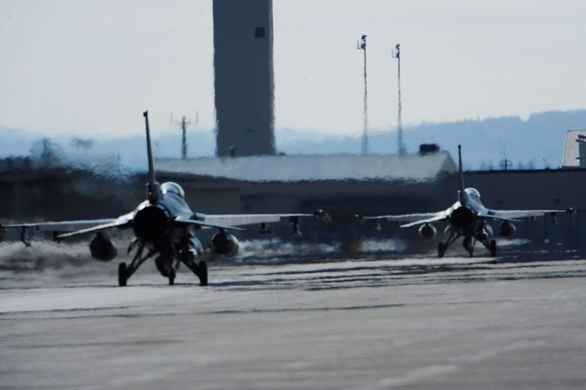 Two F-16 Fighting Falcon, 35th Fighter Squadron, Kunsan Air Base, Korea taxi down the flightline after returning from a training mission, April 20, 2009, Eielson Air Force Base, Alaska. The 35th FS is taking part in Red Flag-Alaska 09-2, a multi-service, multi-platform coordinated, combat operations exercise, which runs from April 16 through May 1.  (U.S. Air Force Photo/Senior Airman Jonathan Snyder)