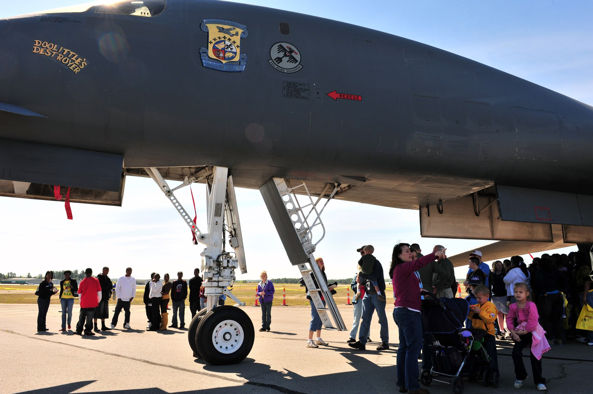 A crowd gathers under a B-1 Lancer during a Doolittle Raider reunion April 17 at Columbia Metro Airport in Columbia, S.C. The B-1 from the 34th Bomb Squadron at Ellsworth Air Force Base, S.D., was unveiled with the Raider patch painted beside the canopy. (U.S. Air Force photo/Senior Airman William Coleman)