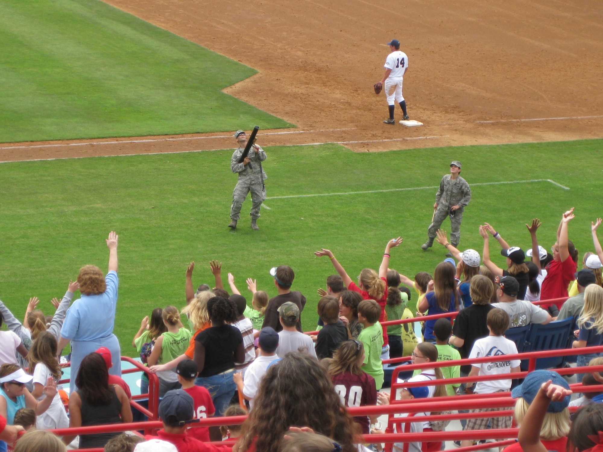 Staff Sgts. Andre De Lira and Cindi Hernandez shoot T-shirts into the crowd of baseball fans April 15 during a minor league game with the Brevard Manatees in Melbourne, Fla. The two noncommissioned officers are assigned to the 333rd Recruiting Squadron. (U.S. Air Force photo)