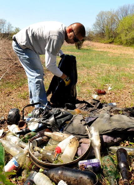 Chief Machinery Technician Robert Velazquez, U.S. Coast Guard Station Washington, collects trash April 17 in one of the historic cemeteries at Saint Elizabeth’s Hospital Washington, D.C. Volunteers from Bolling, including Coast Guard members, dedicated their time to help Saint Elizabeth’s clear out overgrown brush and vines, and pick up trash in preparation to restoring their cemetery. The cemetery is the final resting place of nearly 4,000 veterans – 1,871 military veterans from the Civil War, War of 1812, Spanish-American War and World War I and 2,000 that fought a battle against mental illness. (U.S. Air Force photo by Senior Airman Marleah Miller)