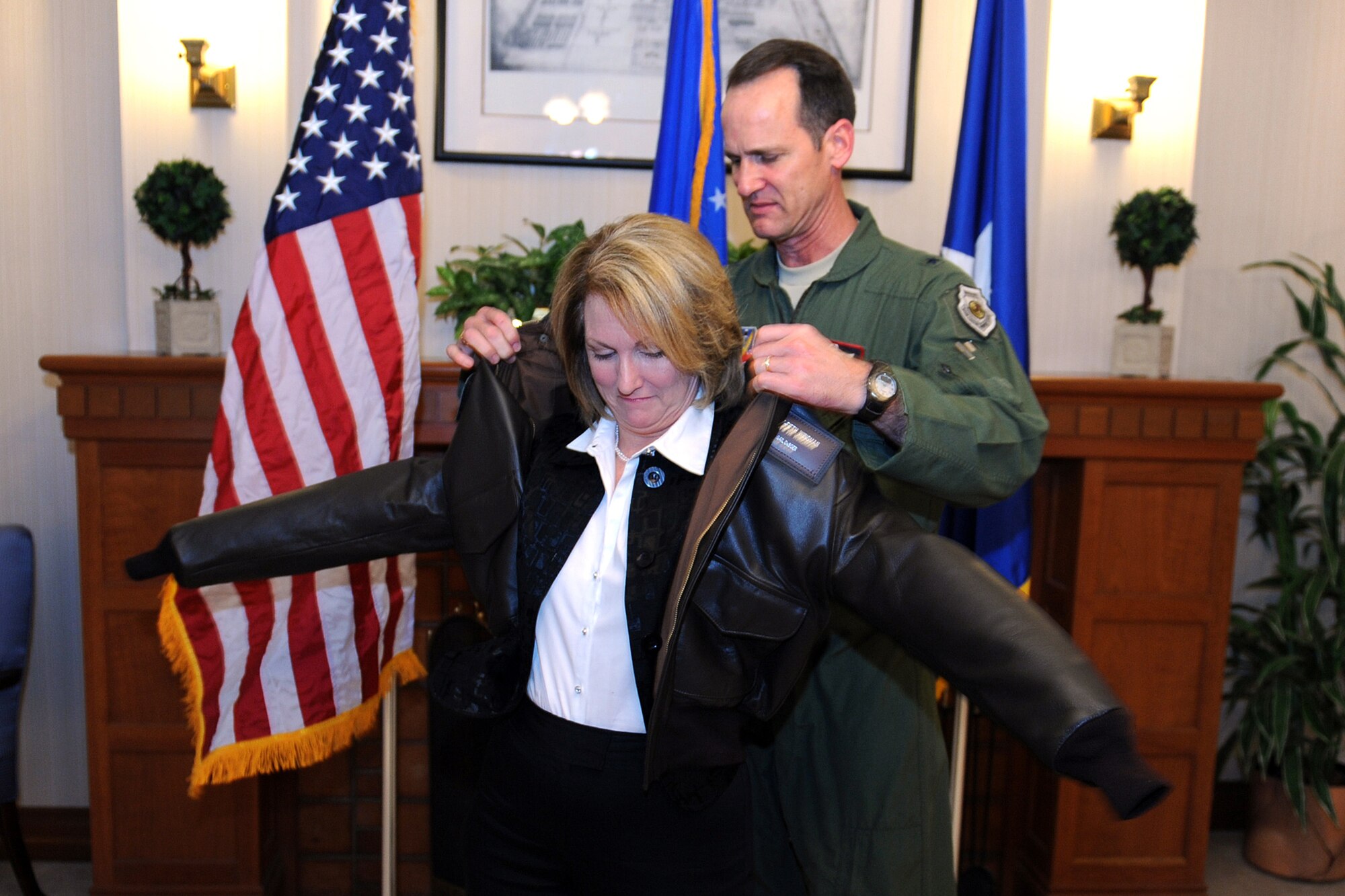 OFFUTT AIR FORCE BASE, Neb. - Brig. Gen. James Jones, 55th Wing commander, assists Gail DeBoer as she dons an honorary Wingman flight jacket during a small ceremony April 17. Mrs. DeBoer is the 15th civilian community member to be designated as a 55th WG Wingman for her constant support of Offutt military members and their families.

U.S. Air Force Photo by Josh Plueger
