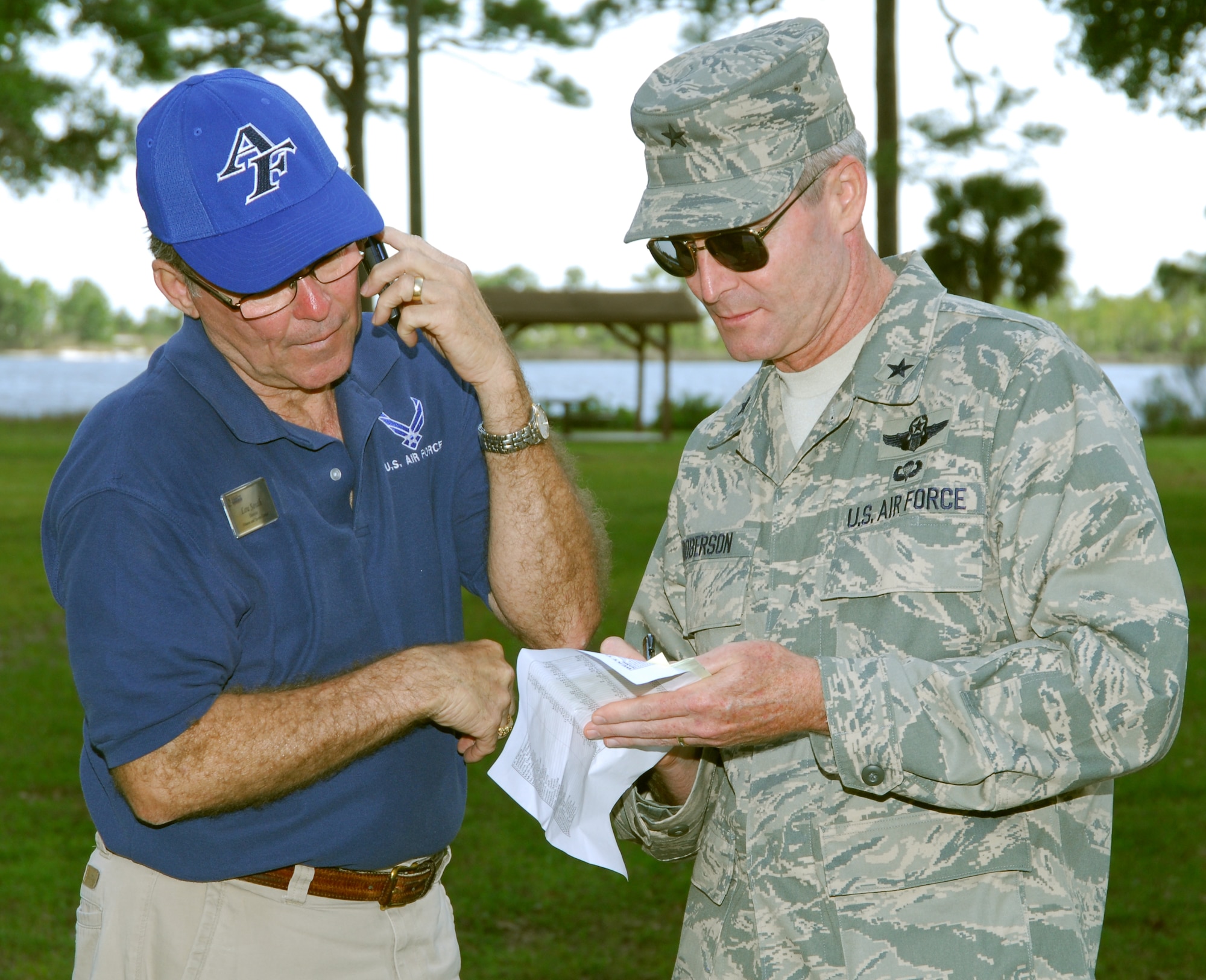 (Left) Lou South, 325th Force Support Squadron fitness director, confers with Brig. Gen. Darryl Roberson, 325th Fighter Wing commander, about the winners of both the "Beat the Boss" and "Biggest Loser" competitions at Heritage Park here. The results of both contests were announced to an eager audience at the 325 FSS's "Spring Fling" event April 17. (U.S. Air Force photo/Lisa Norman)