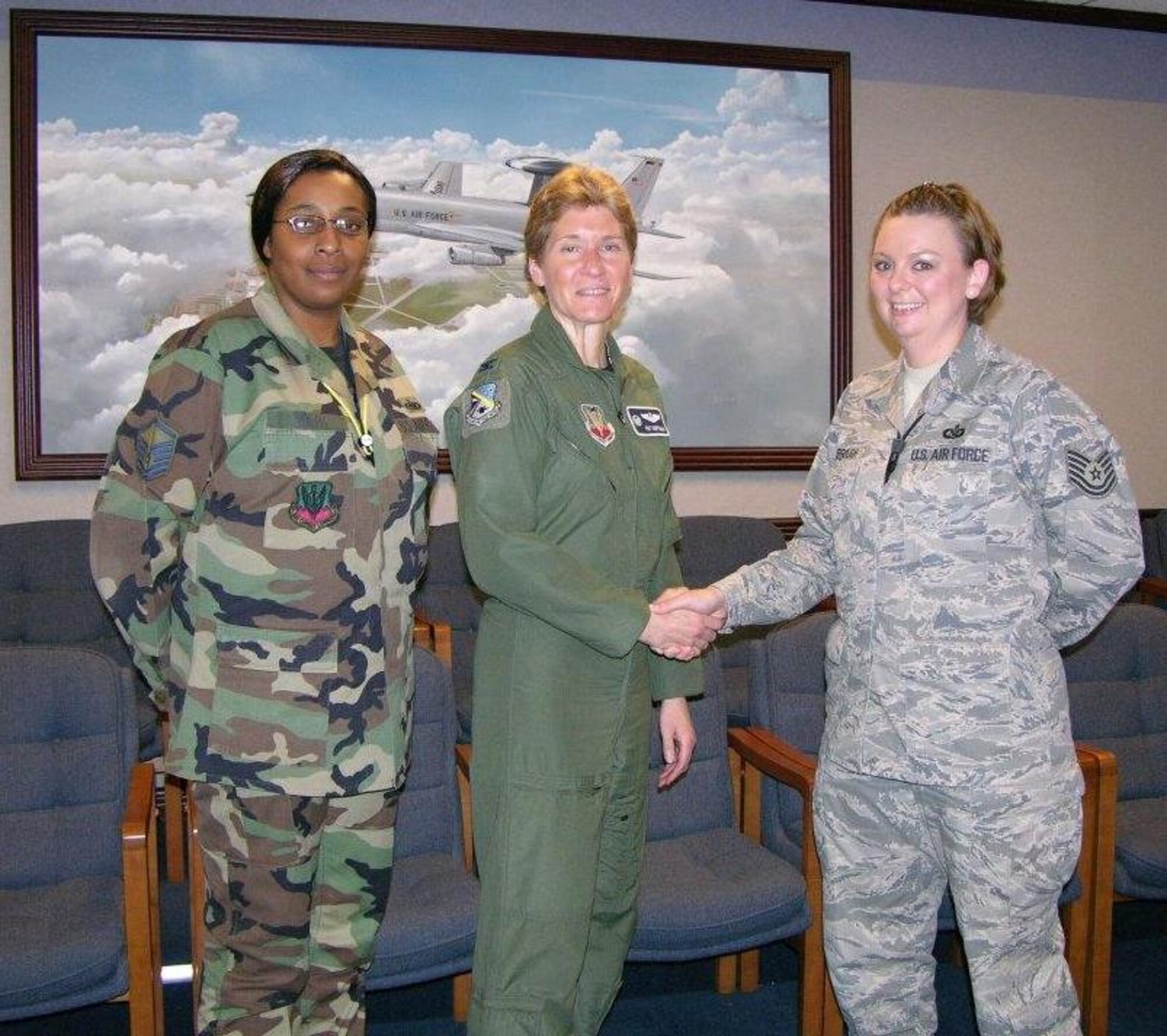 552nd Air Control Wing Commander Col. Pat Hoffman congratulates Tech. Sgt. Ashley Kimbrough on her certification as an Emergency Actions Controller for the 
552 ACW Command Post. Master Sgt. Rachel Polite (left) happily welcomes Sgt. Kimbrough to the 552 ACW Command Post team. 