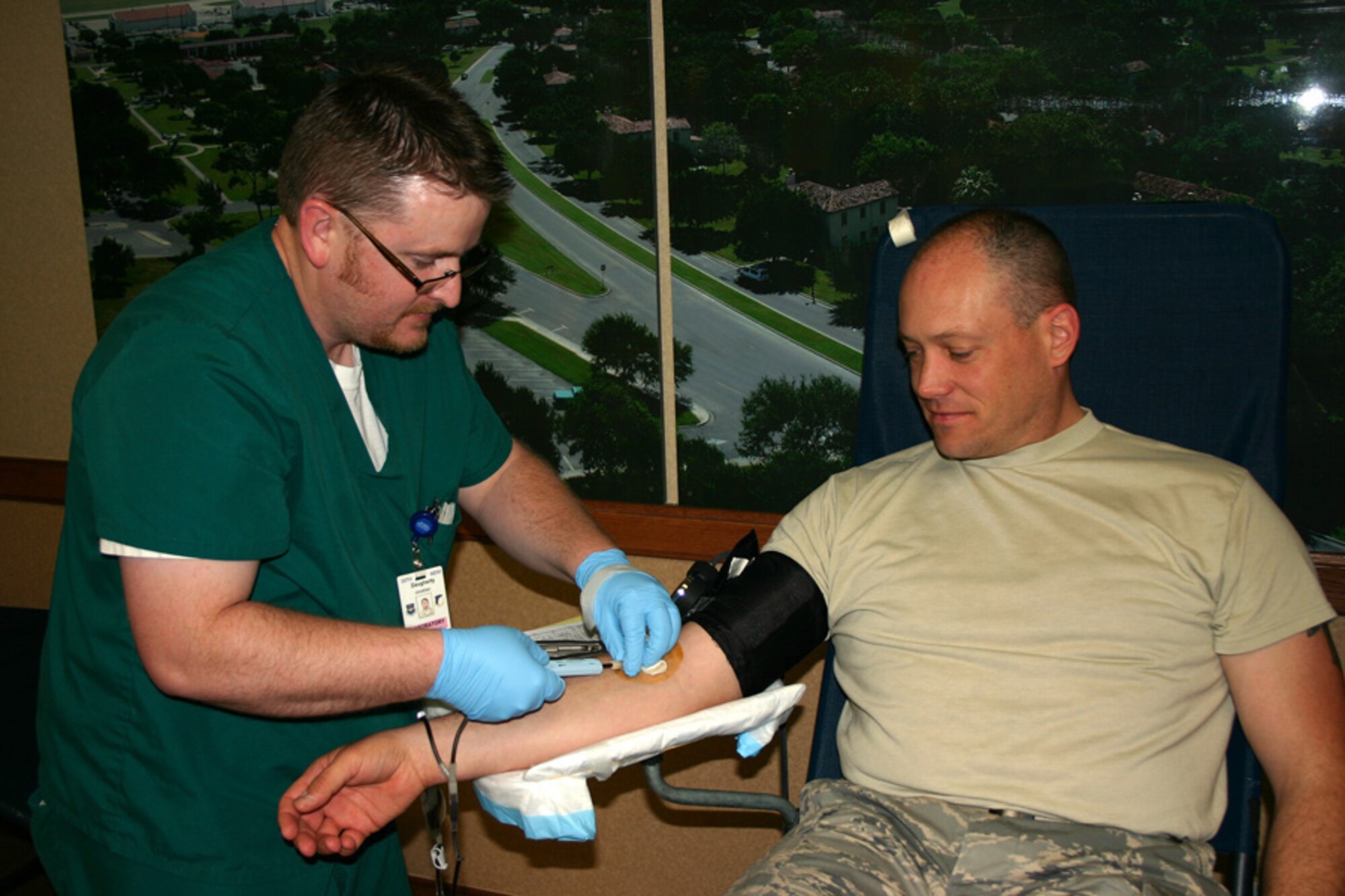 Phlebotomist Jonathan Dougherty draws blood from Maj. Lance Van Vleck, Air Force Personnel Center non-rated officer assignments, during a blood drive held at AFPC April 17 at Randolph Air Force Base, Texas. AFPC members gave more than 40 pints of blood that will be used to supply life-saving blood products to warfighters in Operation Iraqi Freedom and Operation Enduring Freedom. Mr. Dougherty is from the Blood Donor Center at nearby Lackland AFB, Texas  (Air Force photo/Staff Sgt. Steve Grever)