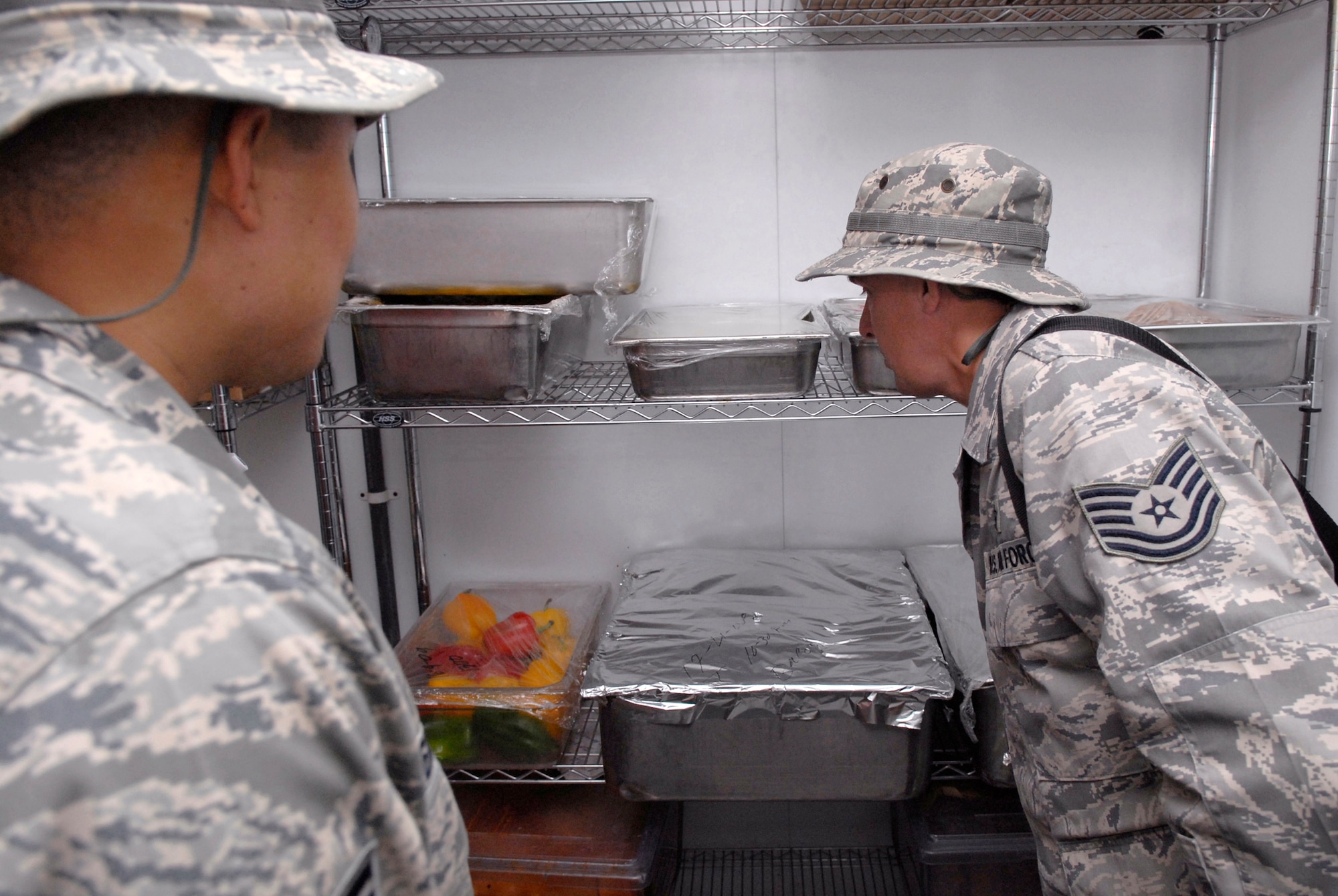 Staff Sgt. Rommel Hernandez, 379th Expeditionary Medical Group (EMDG) public health inspector, and Tech. Sgt. Duwayne Foster, 379th EMDG NCO in charge of public health, inspect food in cold storage at the Independence Dining Facility to ensure the food is properly refrigerated during their monthly dining facility inspection, Apr. 18, 2009, at an undisclosed location in Southwest Asia.  The Public Health office inspects the dining facilities, checks personnel medical records, and provides medical intelligence for forward deployers.  Sergeant Hernandez hails from Arlington, Va.  Sergeant Foster hails from Mobile, Ala.  Both are deployed from Keesler Air Force Base, Miss. in support of Operations Iraqi and Enduring Freedom and Combined Joint Task Force - Horn of Africa.  (U.S. Air Force photo/Senior Airman Andrew Satran/released)
