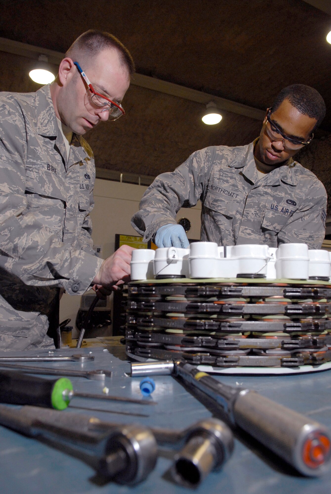Tech. Sgt. Wayne Birk, 379th Expeditionary Maintenance Squadron (EMXS) hydraulics shop chief, and Senior Airman Joseph Northcutt, a 379th EMXS hydraulic journeyman, build a steel brake assembly for a KC-135 Stratotanker, Apr. 17, 2009, at an undisclosed location in Southwest Asia.  The base hydraulic shop supports all of the C-135 airframes in the U.S. Central Command's Area of Responsibility.  Sergeant Birk hails from Brockton, Mass. and is deployed from Grand Forks Air Force Base, N.D.  Airman Northcutt hails from Los Angeles, Calif. and is deployed from Fairchild Air Force Base, Wash.  Both are deployed in support of Operations Iraqi and Enduring Freedom and Combined Joint Task Force - Horn of Africa.  (U.S. Air Force photo/Senior Airman Andrew Satran/released)