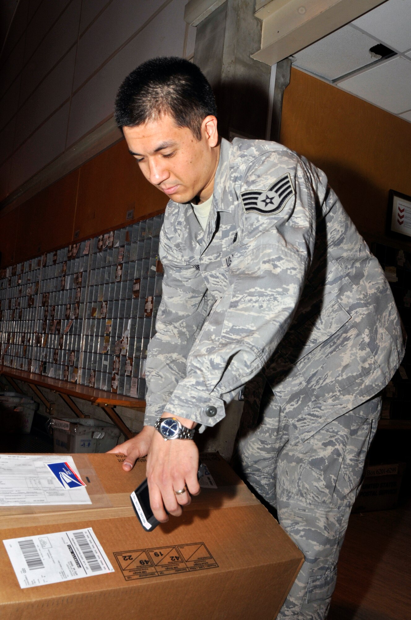 ROYAL AIR FORCE LAKENHEATH -- Staff Sgt. Adrian Alcantara, 48th Communications Squadron postal service center supervisor, scans in a package here April 15. RAF Lakenheath post office has scanned the arrival and delivery of over 117 thousand parcels since Septmber 2008, the highest for any Air Force location. (U.S. Air Force photo by Airman 1st Class Perry Aston) (Released)