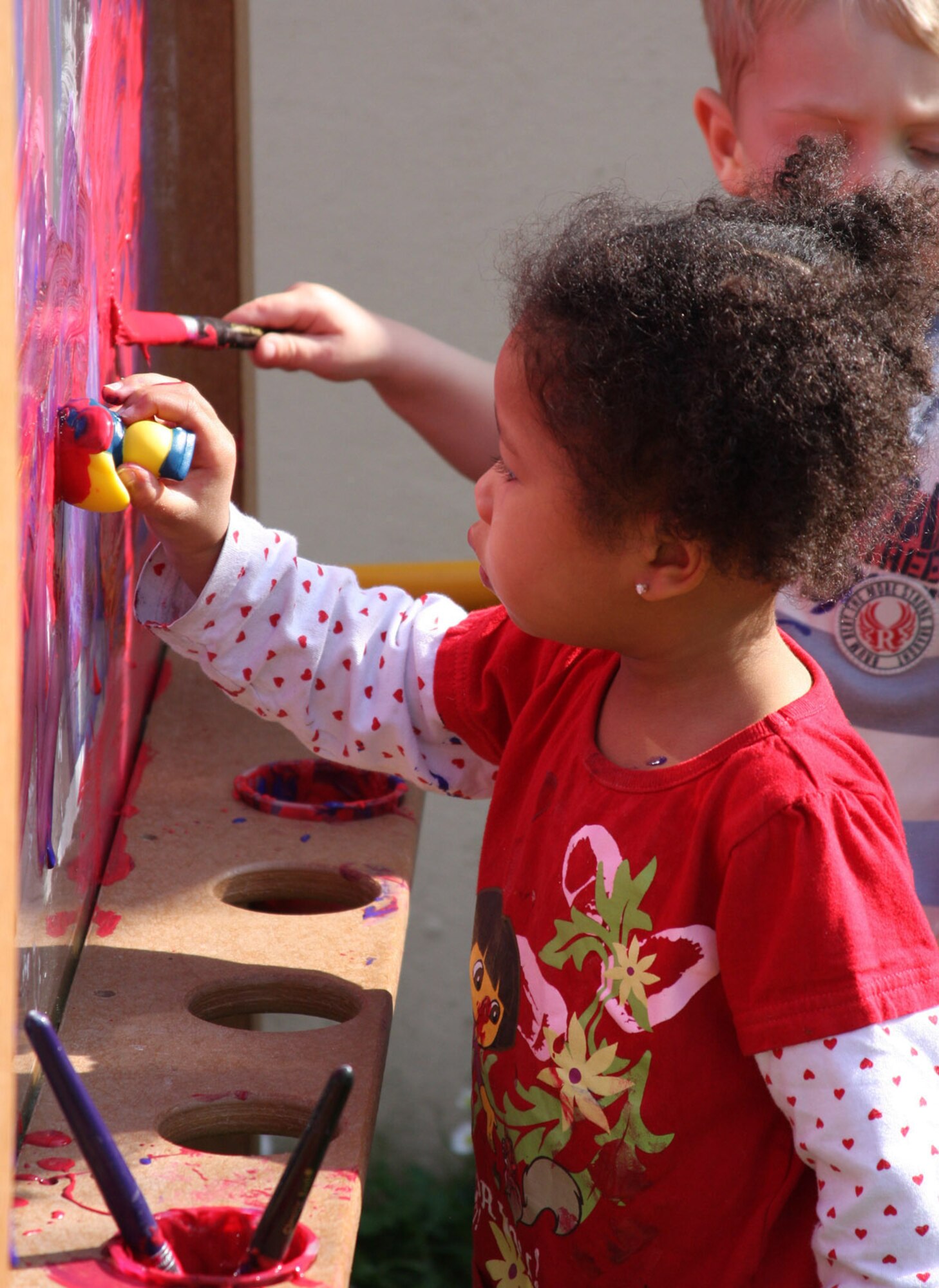 Anice Long, daughter of Staff Sgt. Demetrius and Lisa Long, paints a picture for her parents after the Area 1 Child Development Center's Annual Month of the Military Child Parade earliler this month. After the parade, parents were invited to the CDC to enjoy crafts, games and snacks with their children. (U.S. Air Force photo/Rebecca White)