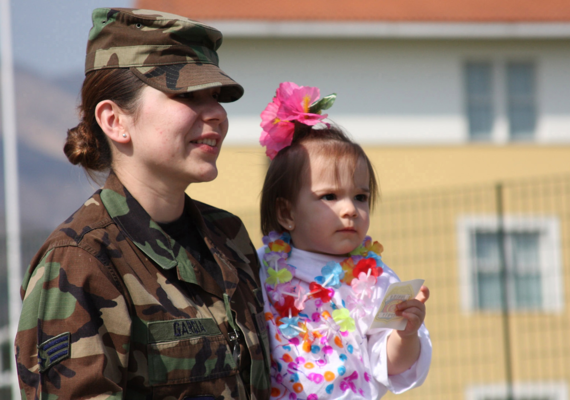Senior Airman Lizzette Garcia and her daughter Arianna Henne participate in the Area 1 Child Development Center's Annual Month of the Military Child Parade earliler this month. After the parade, parents were invited to the CDC to enjoy crafts, games and snacks with their children. (U.S. Air Force photo/Rebecca White)