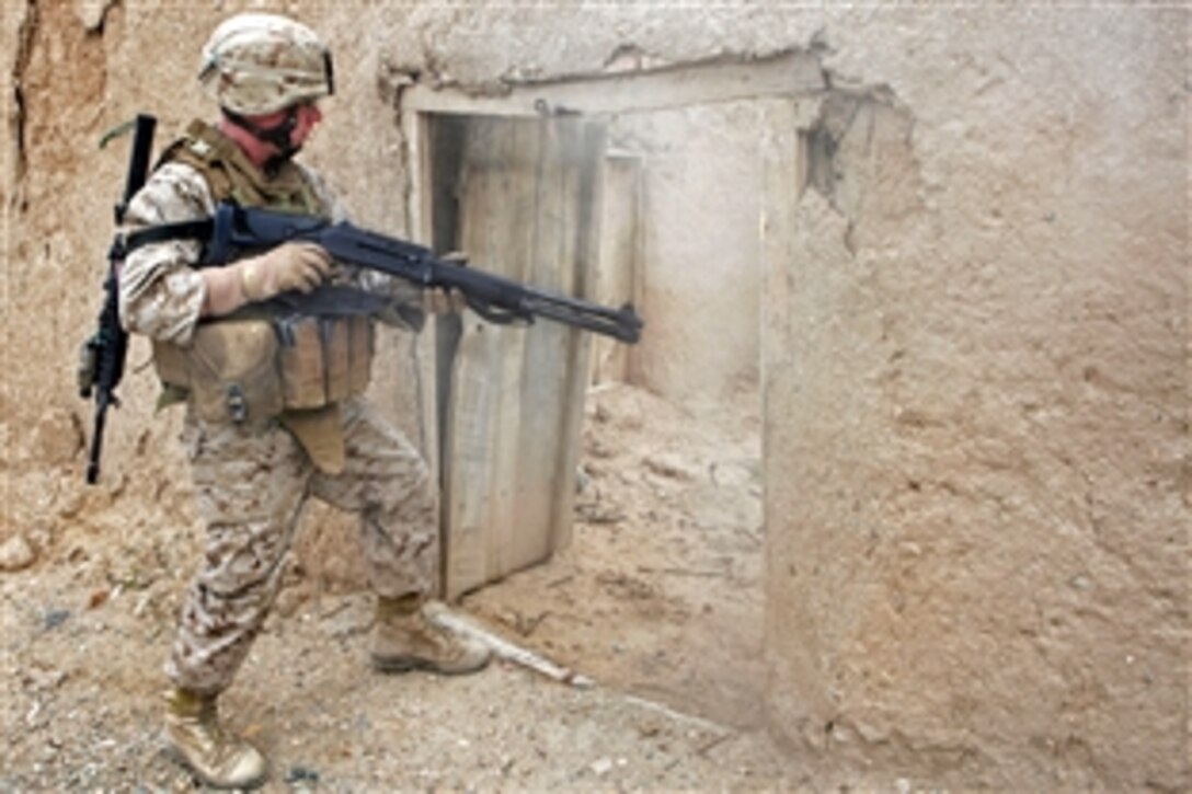 U.S. Marine Corps Lance Cpl. Garrett Coxwell breaches a door to set up an overwatch position during a local security patrol in Helmand province, Afghanistan, April 9, 2009. Coxwell is assigned to Lima Company, 3rd Battalion, 8th Marine Regiment. The Marines are conducting security patrols to prevent enemy freedom of movement.