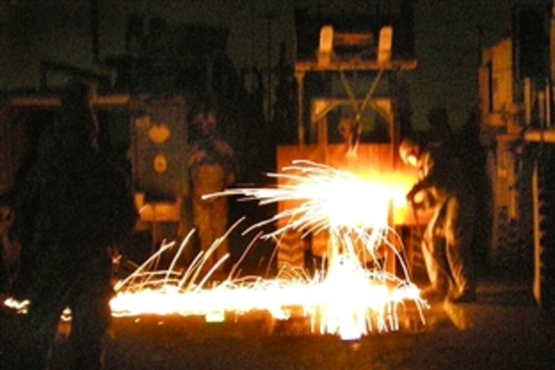 Sparks fly as welders from the 46th Engineer Combat Battalion, 225th Engineer Brigade, ensure access to underground tunnels are shut off to terrorists in Baghdad, Iraq, April 19, 2009. The engineers were called out to fix the holes left by a previous bombing.