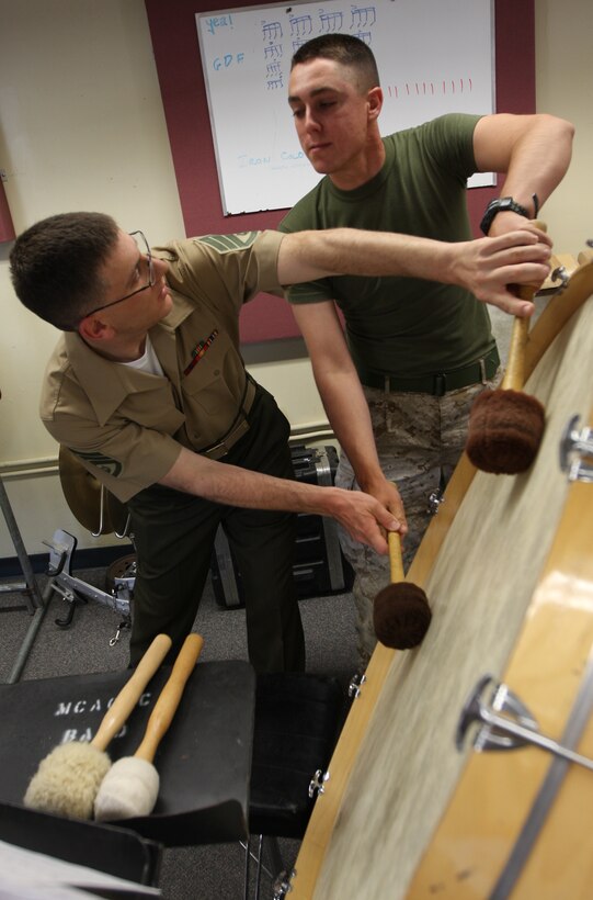 Staff Sgt. Jonathan Bisesi, a percussionist with “The President’s Own” United States Marine Band, mentors a percussionist in the Combat Center band as they practice for the April 26 show at the Sunset Cinema.