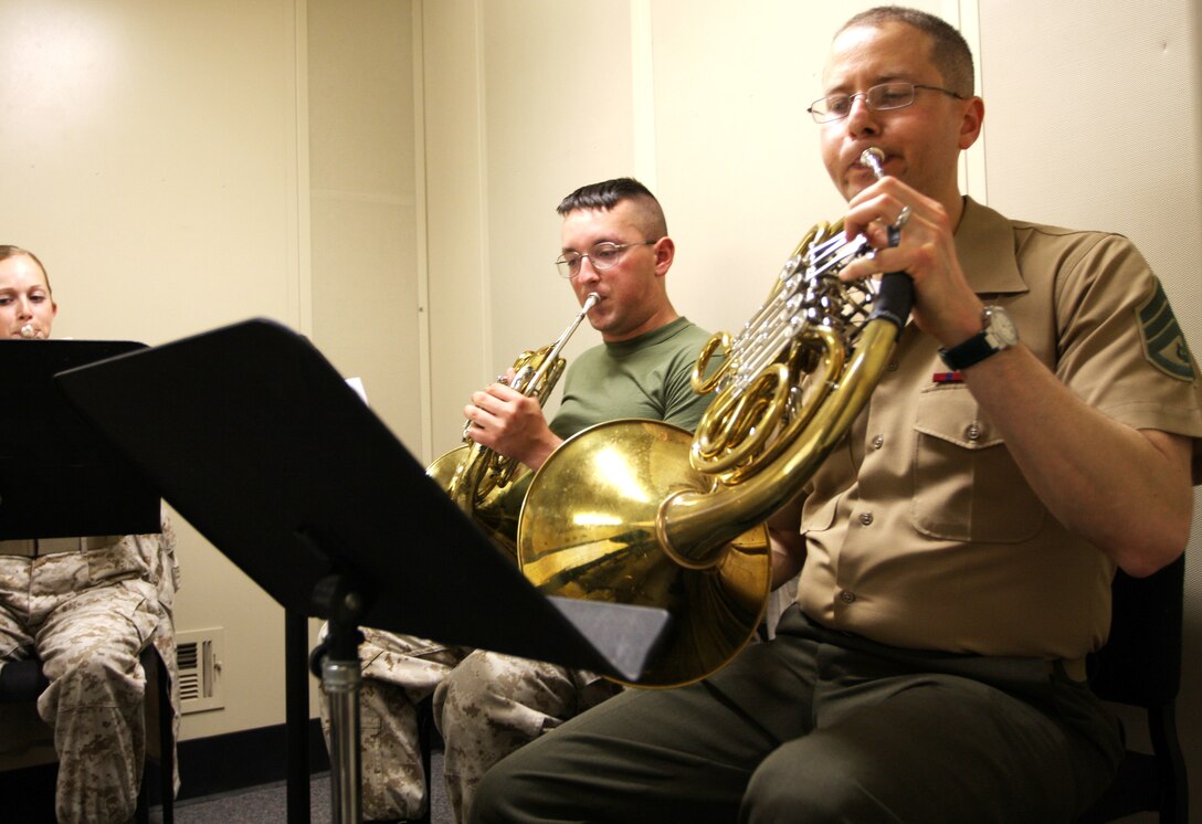Staff Sgt. Gabriel Gitman, a French horn player in “The President’s Own” United States Marine Band, makes music with members of the Combat Center band as they prepare to perform April 26 at the Sunset Cinema.