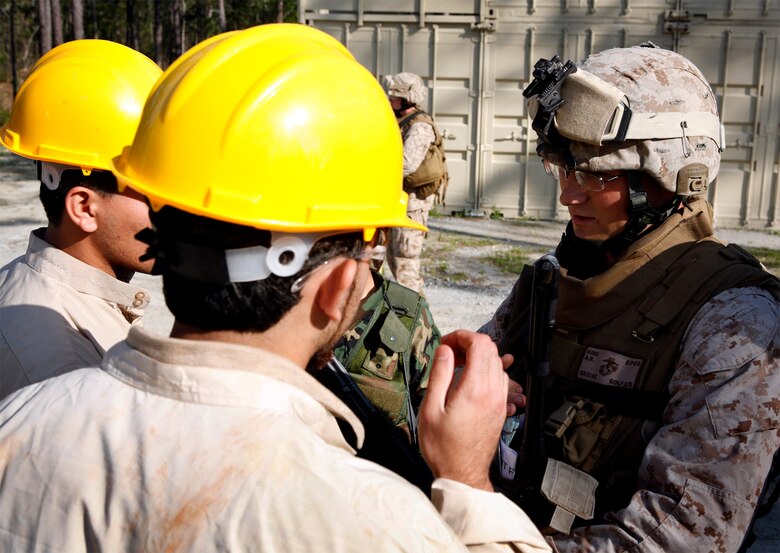 Cpl. Adam King, a 23-year-old squad leader with Company G, 2nd Battalion, 8th Marine Regiment, 2nd Marine Division, speaks to Afghan role players during culture training, here, April 21. As part of the scenario based training, King and his squad met with water and electric workers about their community’s essential services, like what they may face in theater. (Official U.S. Marine Corps photo by Cpl. Scott Schmidt) (RELEASED)