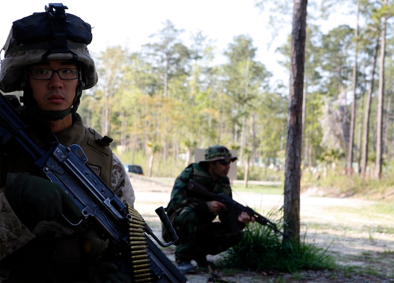 Lance Cpl. Jesse Yeon, a squad automatic rifleman with Company G, 2nd Battalion, 8th Marine Regiment, 2nd Marine Division, halts during a training scenario with foreign national role players at the Military Operations in Urban Terrain facility, here, April 21. “The scenarios are designed to enhance cultural understanding for when we deploy,” explained Cpl. Adam King, a 23-year-old squad leader with Company G. “We’ve been preparing ourselves to better interact with the people of Afghanistan. Today, that knowledge was refined and put to the test talking with the role players.” (Official U.S. Marine Corps photo by Cpl. Scott Schmidt.) (RELEASED)
