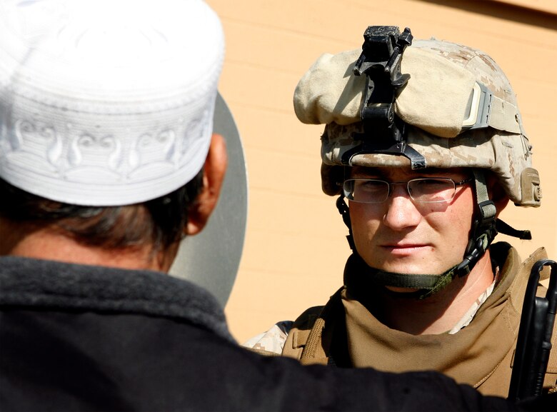 Cpl. Adam King, a 23-year-old squad leader with Company G, 2nd Battalion, 8th Marine Regiment, 2nd Marine Division, speaks to an Afghan role player during culture training, here, April 21. As squads patrolled through the Military Operations in Urban Terrain facility, role players, mostly foreign nationals, played music, cooked food and manned shops to depict what Marines will encounter while on patrol through a village. (Official U.S. Marine Corps photo by Cpl. Scott Schmidt.) (RELEASED)