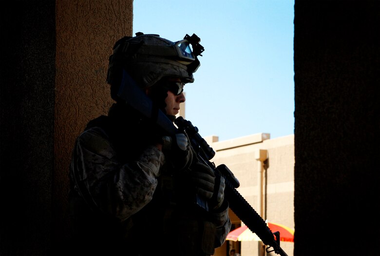 Lance Cpl. Sean Corvuno, a 22-year-old team leader with Company G, 2nd Battalion, 8th Marine Regiment, 2nd Marine Division, peers through a door way during culture training at the Military Operations in Urban Terrain facility, here, April 21. As squads patrolled through the MOUT facility, role players, mostly foreign nationals, played music, cooked food and manned shops depicting what Marines will encounter while on patrol through a village. (Official U.S. Marine Corps photo by Cpl. Scott Schmidt.) (RELEASED)