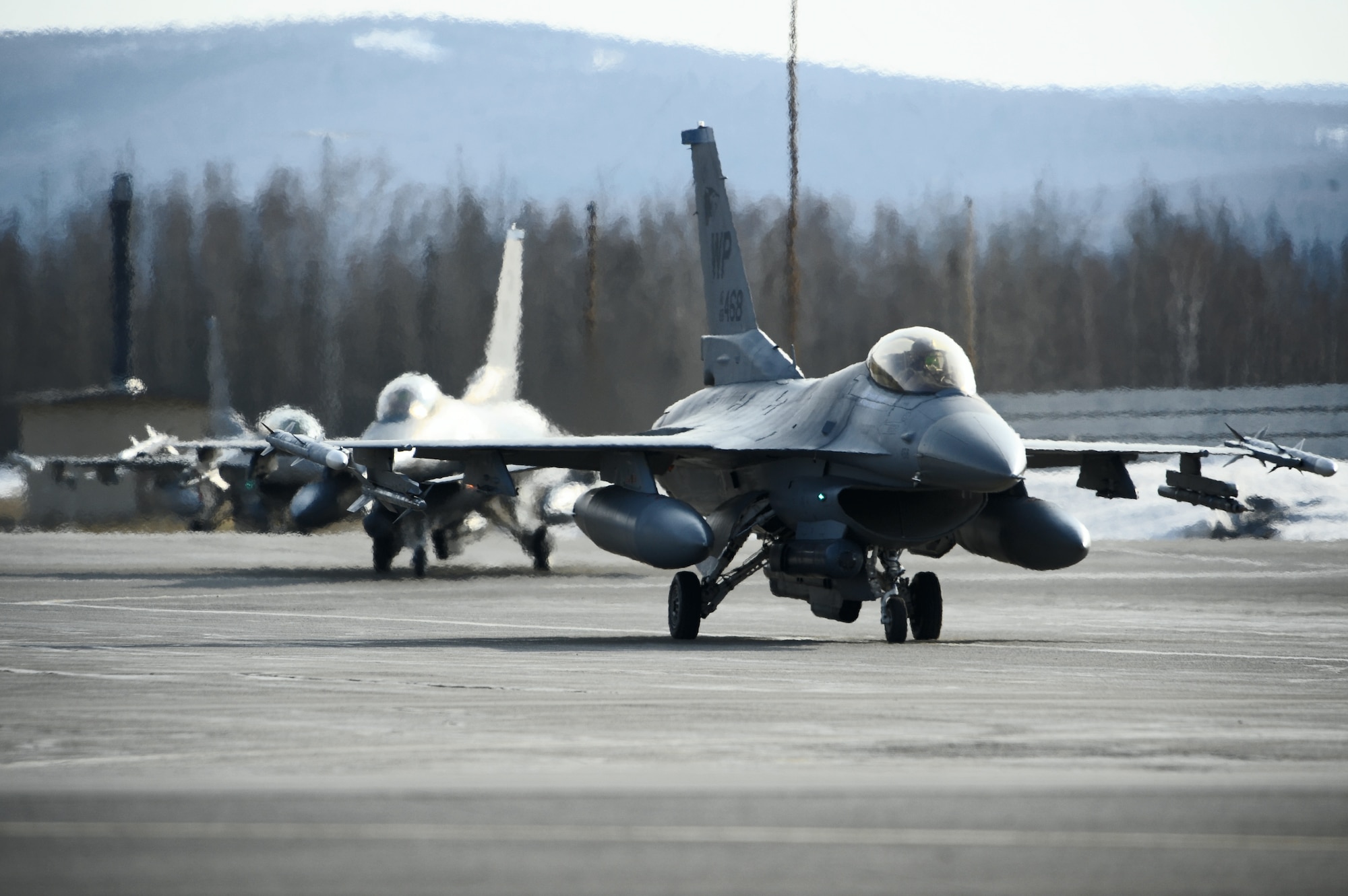 Three F-16 Fighting Falcons, 35th Fighter Squadron, Kunsan Air Base, Korea, taxis towards the end of the runway during RED FLAG-Alaska 09-2 April 21, 2009, Eielson Air Force Base, Alaska. RF-A is a series of Pacific Air Forces commander-directed field training exercises for U.S. forces, providing joint offensive counter-air, interdiction, close air support, and large force employment training in a simulated combat environment.  (U.S. Air Force Photo/Senior Airman Jonathan Snyder)