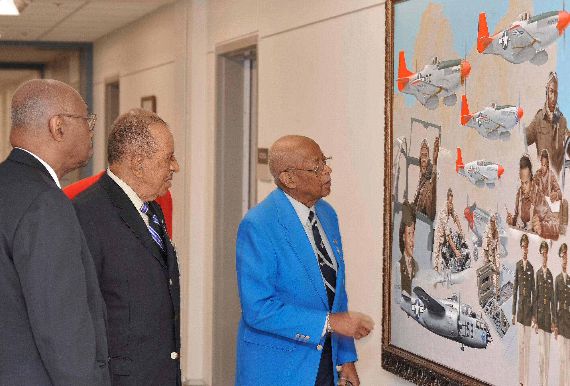 Tuskegee Airmen George Boyd (from left), James Warren, Phillip Broom (in red coat) and Alexander Jefferson admire a painting April 20 depicting fellow Tuskegee Airmen that is on display in the Pentagon.  The four Airmen along with retired Lt. Gen. Russell Davis were in Washington to meet with Air Force Chief of Staff Gen. Norton Schwartz and Air Force Vice Chief of Staff Gen. William Fraser III prior to departing on a tour of units in Southwest Asia including the 332nd Air Expeditionary Wing whose origins trace back to the 332nd Fighter Group and the Tuskegee Red Tail Flyers.  (U.S. Air Force photo/Scott M. Ash)