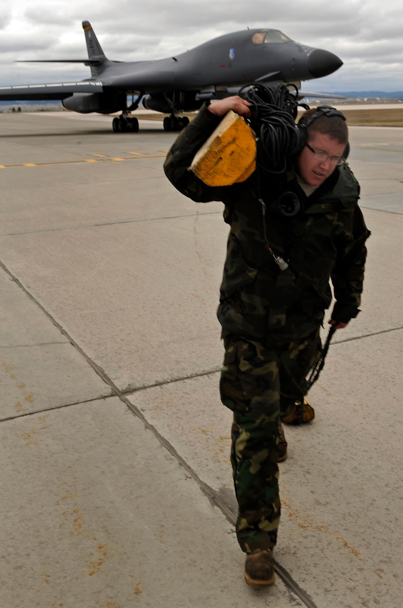 Senior Airman Chris Lee, 28th Aircraft Maintenance Squadron crew chief, removes chocks in preparation for a B-1B Lancer to taxi down the flight line, April 17. The 28 AMXS maintains mission-ready aircraft to conduct worldwide operations. (U.S. Air Force photo/Senior Airman Marc I. Lane)