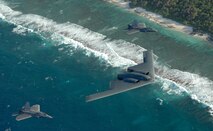 Two F-22 Raptors and one B-2 Spirit deployed to Andersen Air Force Base, Guam, fly in formation over the Pacific Ocean. The aircraft are deployed from the 90th Expeditionary Fighter Squadron and the 13th Expeditionary Bomb Squadron. The deployment to Andersen marks the first time F-22s and B-2s, the key national strategic stealth assets in the Air Force inventory, deployed together outside the continental United States.  (Courtesy photo)